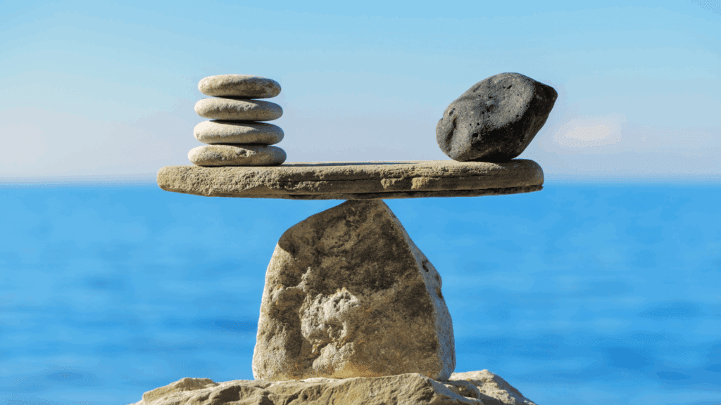 Balanced stones on a seesaw, symbolizing equilibrium.