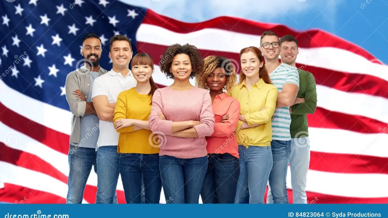 Diverse group of smiling people standing united with an American flag in the background.